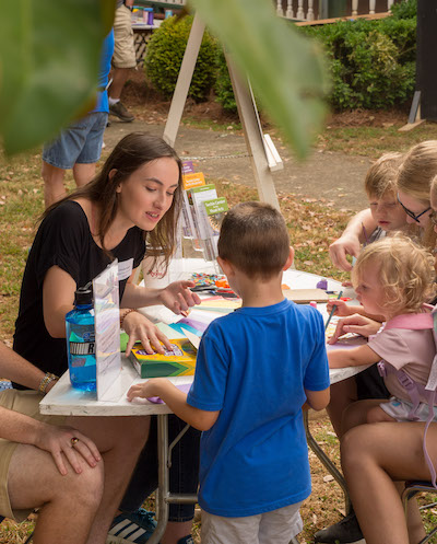 volunteer with children at activity table at Hiddenite Arts & Heritage Center